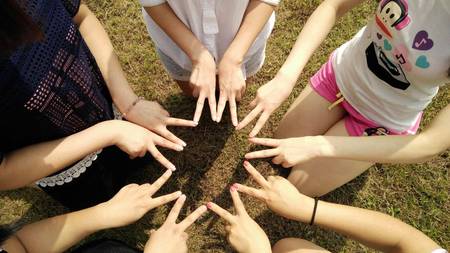 Quelle: pixabay.com/shelley_shang, https://pixabay.com/de/photos/team-freunde-teamarbeit-corporate-1381084/ Gruppe an Teenagern formt mit Händen einen Stern